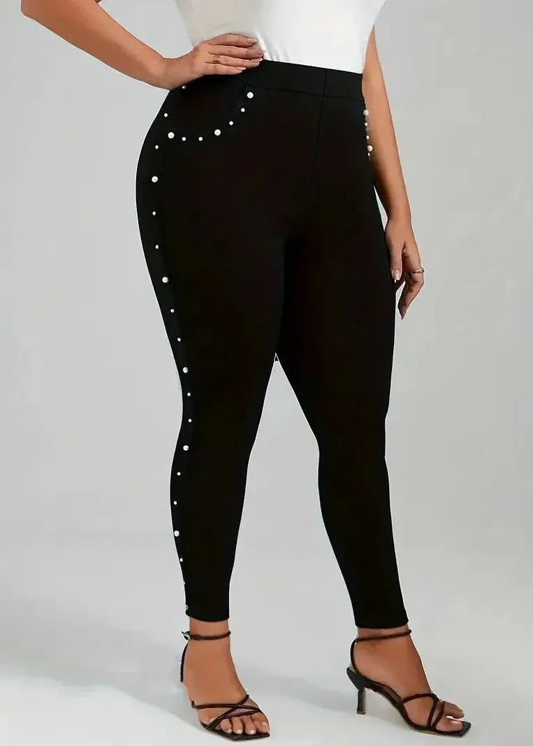 Black leggings with white embellishments worn by a person on a plain background