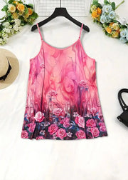 Pink floral dress on a hanger with flowers and a hat in the background