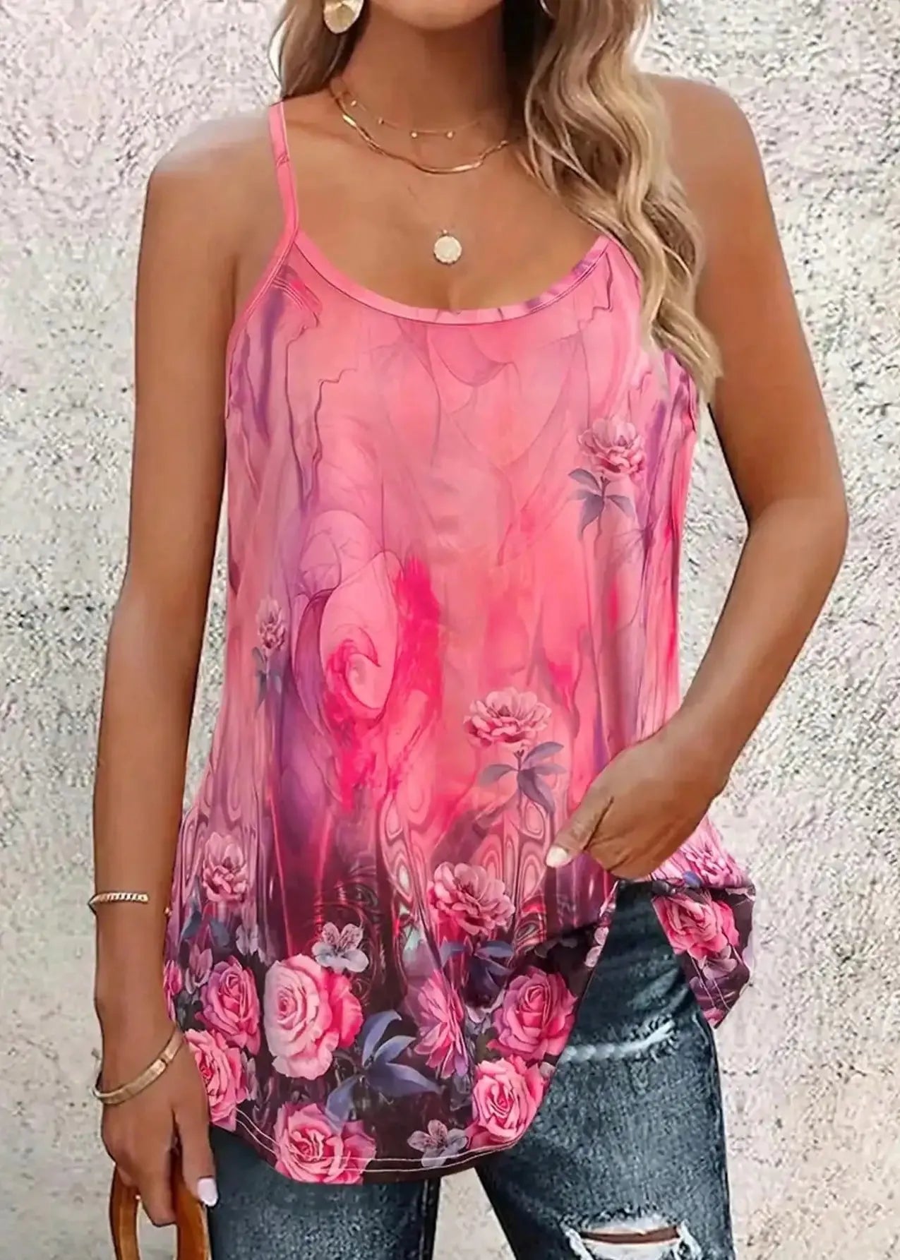 Woman wearing a pink floral tank top against a textured wall.