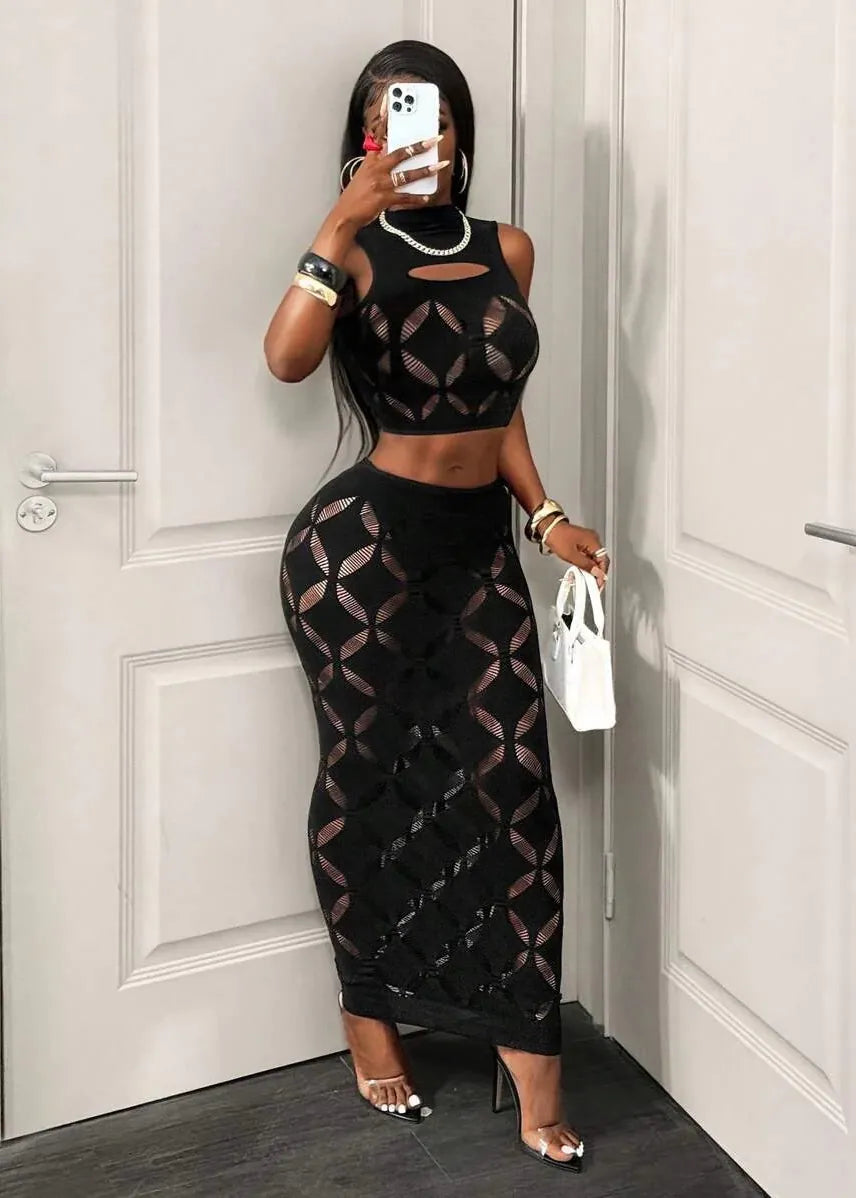 Person wearing a black geometric patterned outfit in front of a white door.