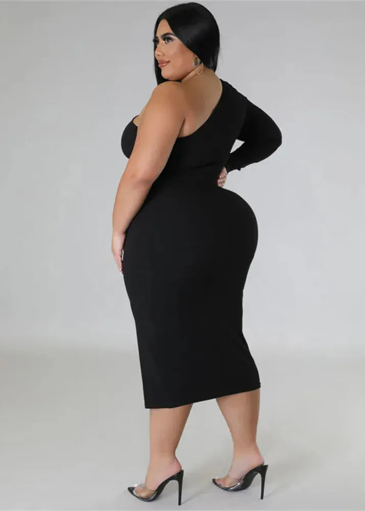 Woman wearing a black dress with cut-out shoulders on a plain background