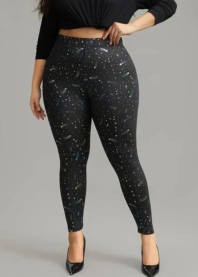 Person wearing black leggings with star pattern on a gray background
