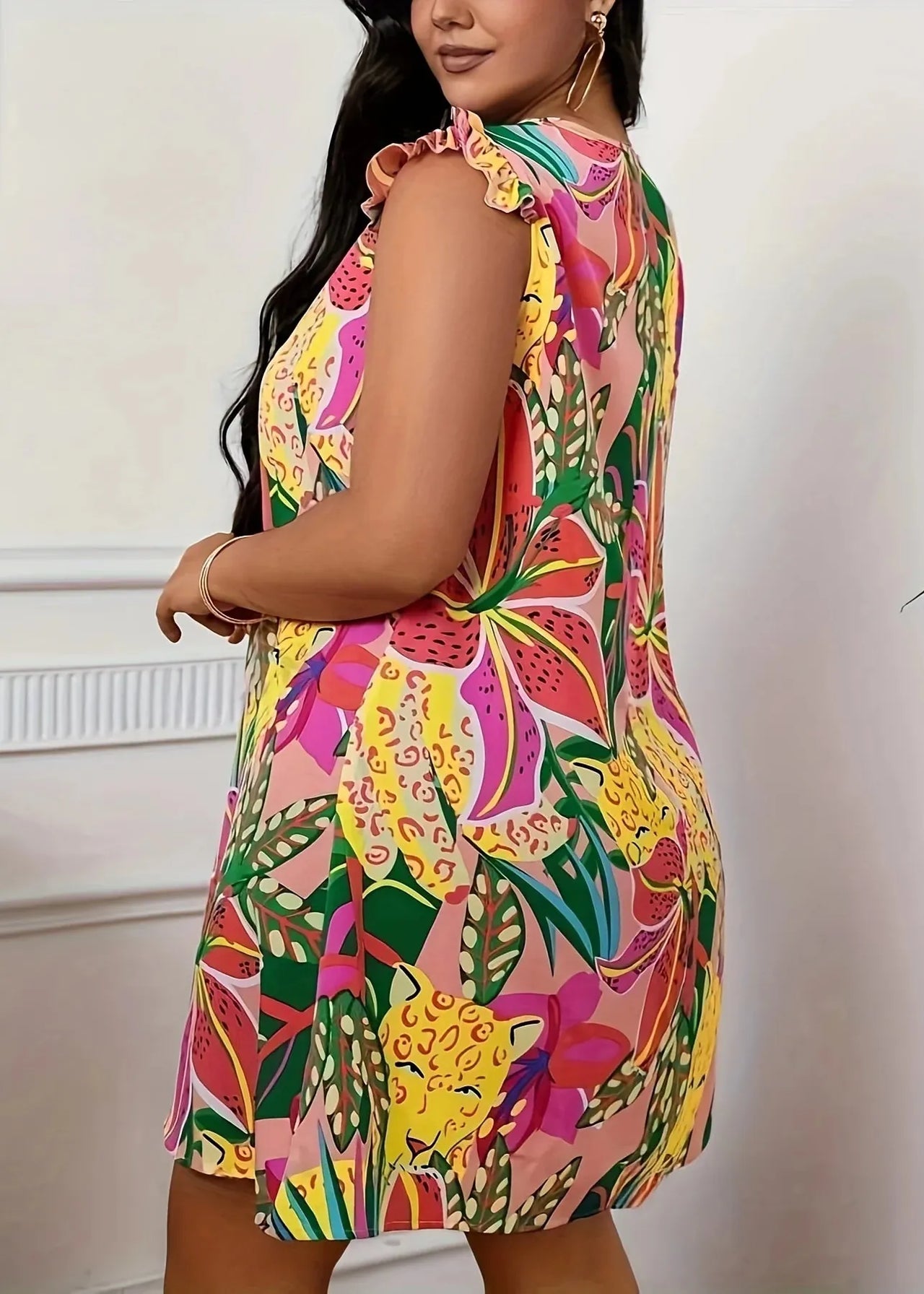 Woman wearing a colorful patterned dress against a neutral background