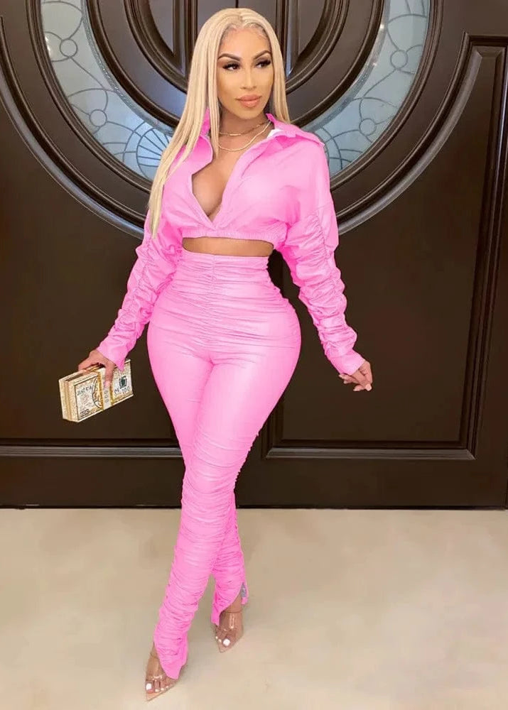 Woman in a pink outfit posing in front of a decorative door.