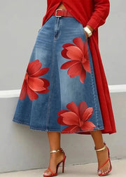Person wearing a red floral denim skirt with a red top and high heels on a gray background