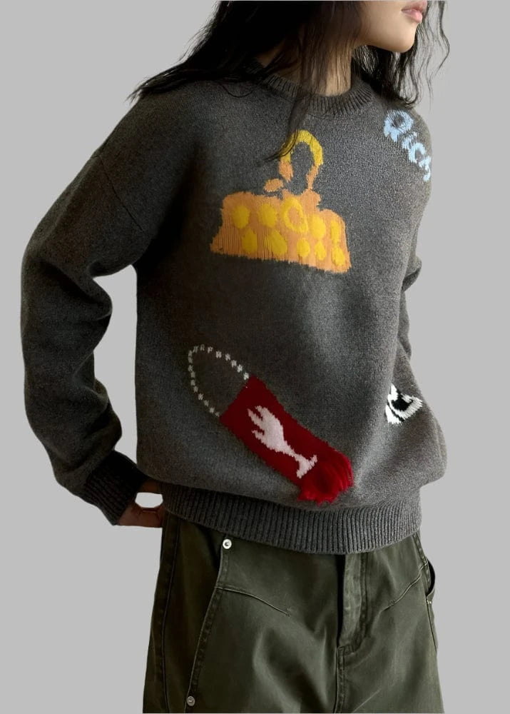 Person wearing a gray sweater with colorful graphic designs, standing against a white background.