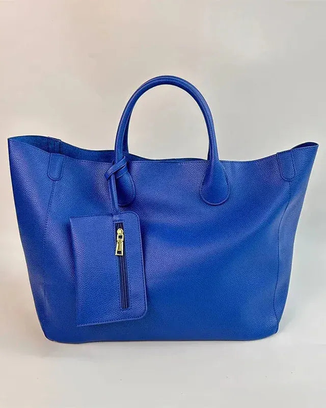 Blue handbag with a pocket and zipper on a light beige background