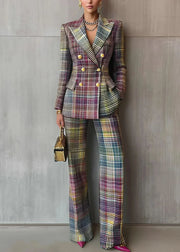 Person wearing a plaid suit with a gold handbag against a gray wall.