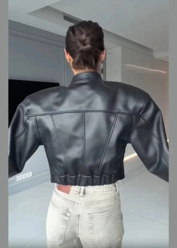 Person wearing a black leather jacket in an indoor setting