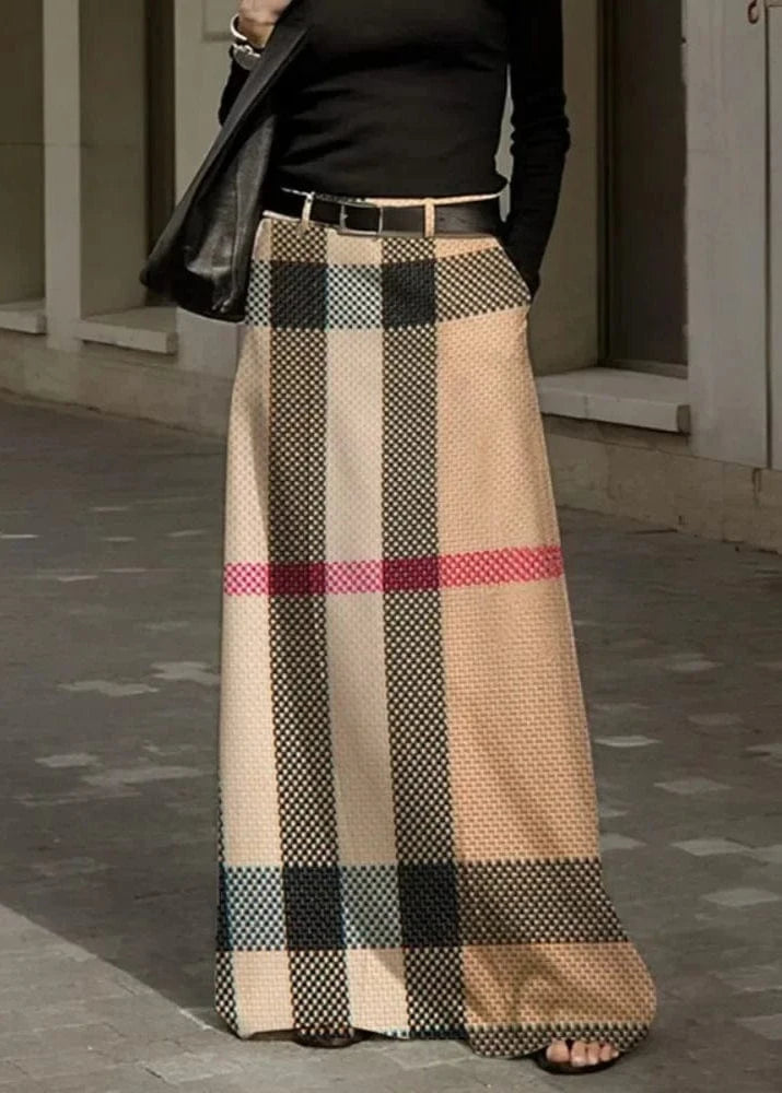 Person wearing a long plaid skirt with a checkered pattern outdoors.