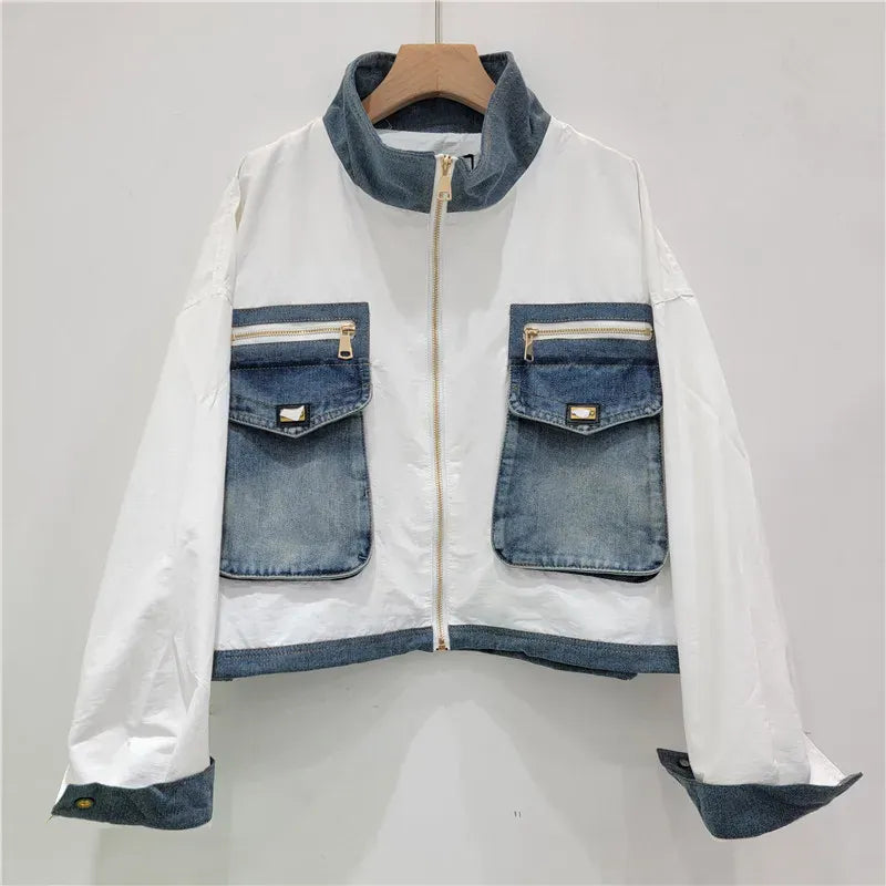 White jacket with denim accents on a hanger against a gray background