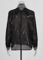 Black sheer blouse with patterned collar and cuffs on a mannequin against a white background