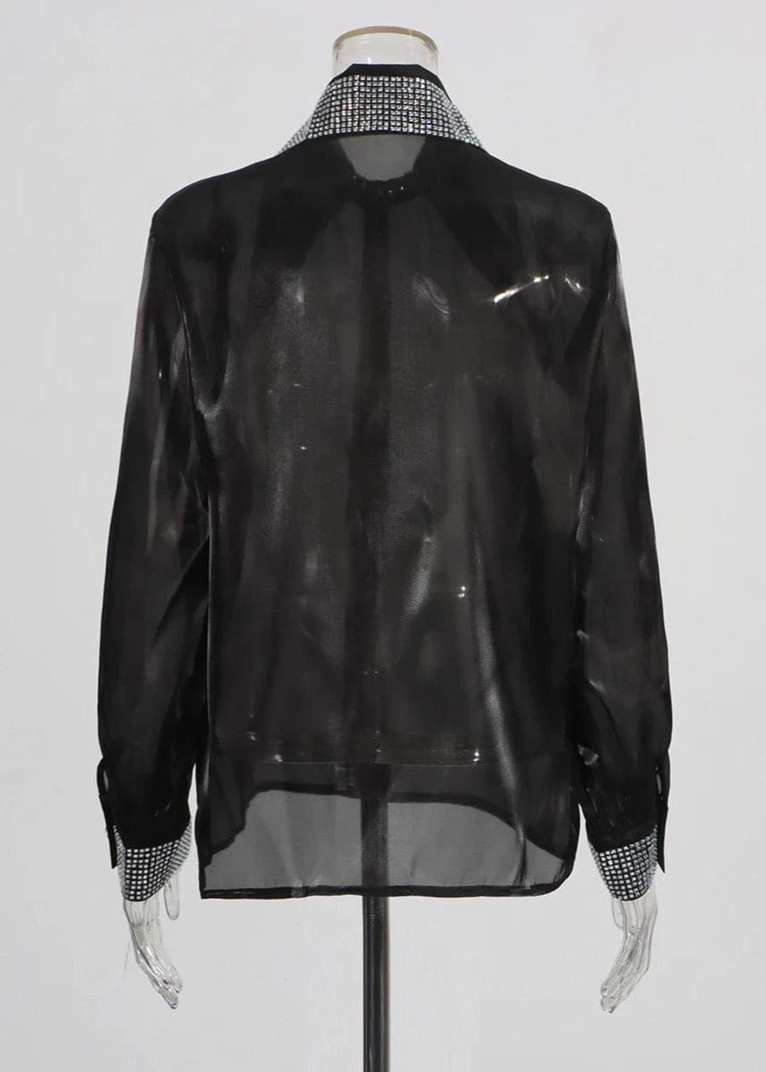 Black sheer blouse with patterned collar and cuffs on a mannequin against a white background