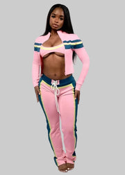 Woman wearing a pink tracksuit with colorful accents on a white background, featuring the brand 'FLARORA'.