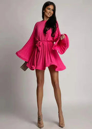 Woman wearing a bright pink dress against a plain background