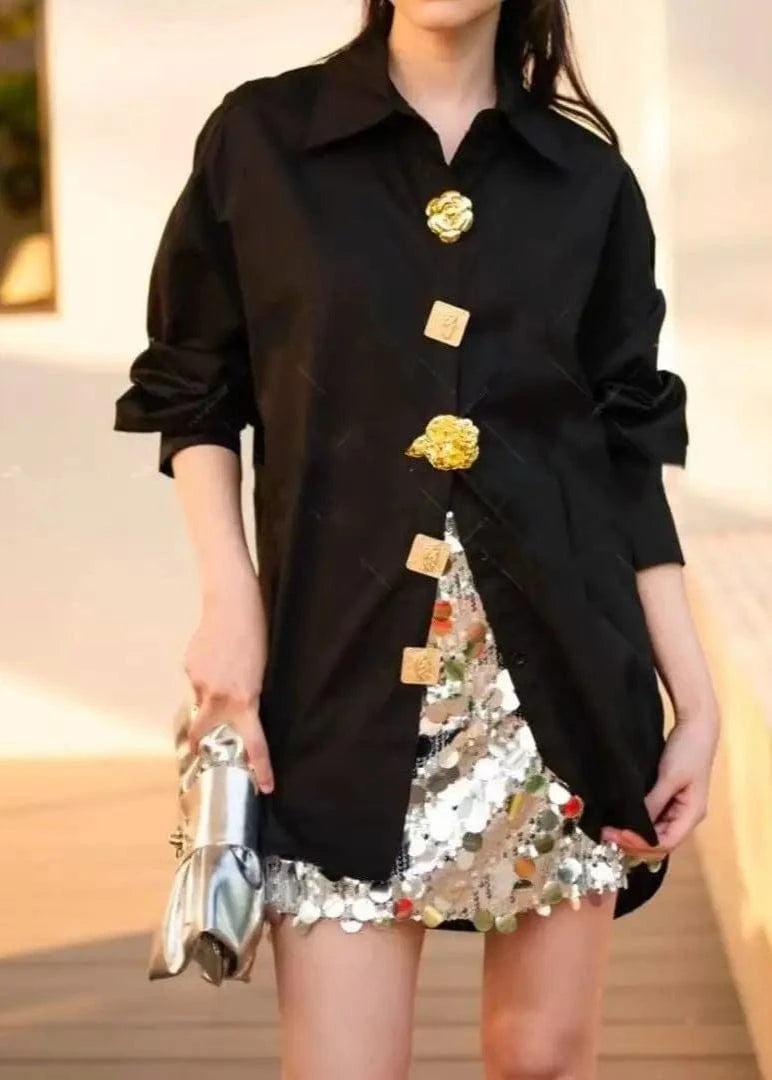 Person wearing a black dress with sequin details outdoors