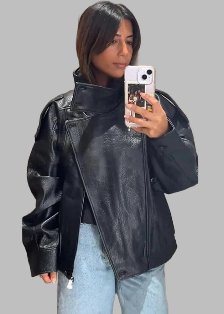 Person wearing a black leather jacket taking a mirror selfie.