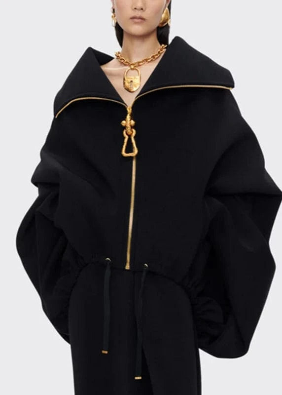 Black coat with gold zipper and trim on a white background