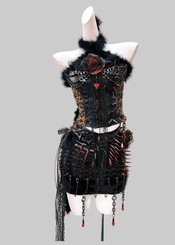 Black decorative dress with floral elements on a mannequin against a light pink background