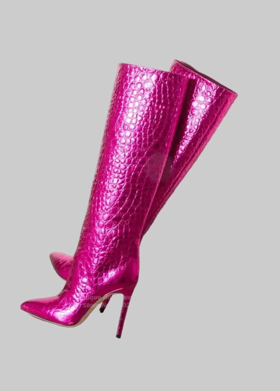 Pink knee-high boots with a textured pattern on a beige surface.