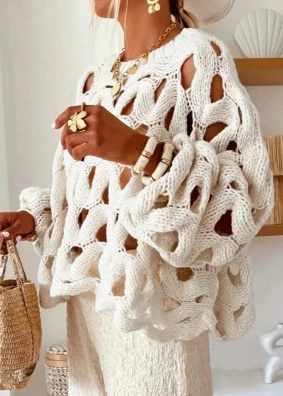 Person wearing a white crochet cover-up with a minimal background