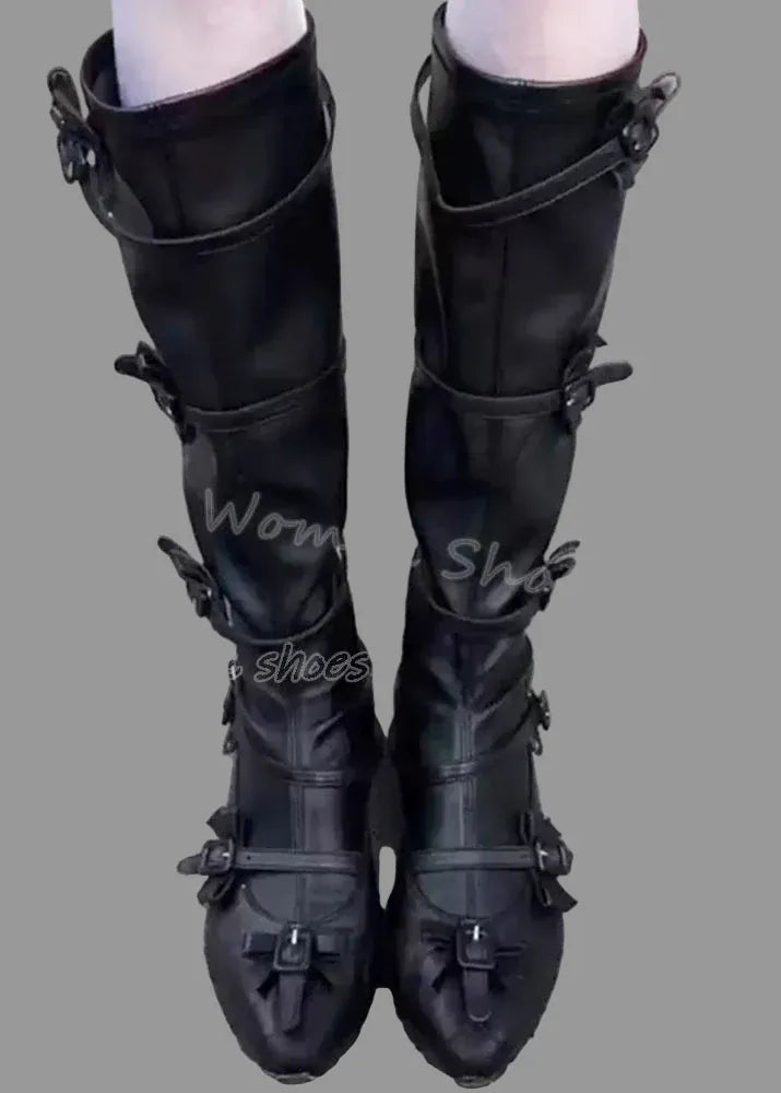 Black knee-high boots with buckles on a concrete surface