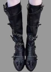 Black knee-high boots with buckles on a concrete surface