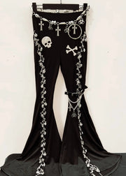 Black pants with decorative chains and skull designs on a hanger against a white background