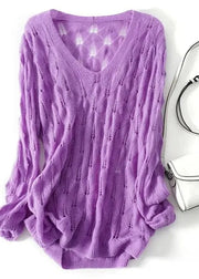 Purple sweater on a white background with a silver handbag.