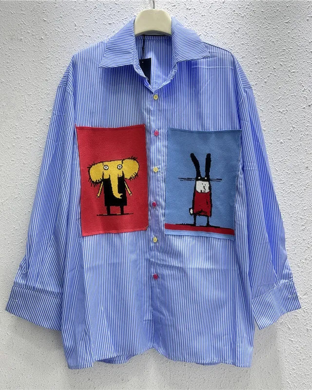 Blue striped shirt with cartoon character patches on a gray background