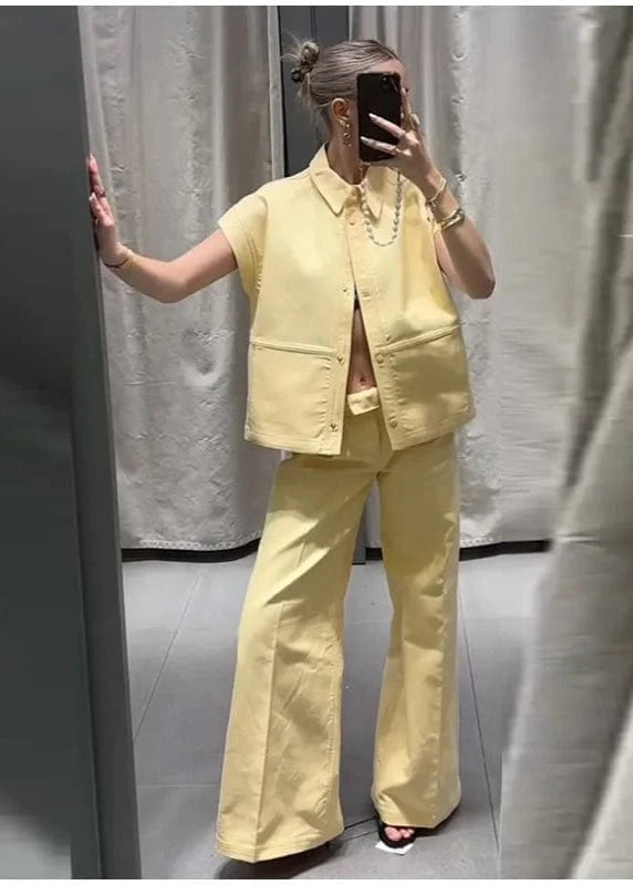 Person wearing a yellow outfit taking a mirror selfie.