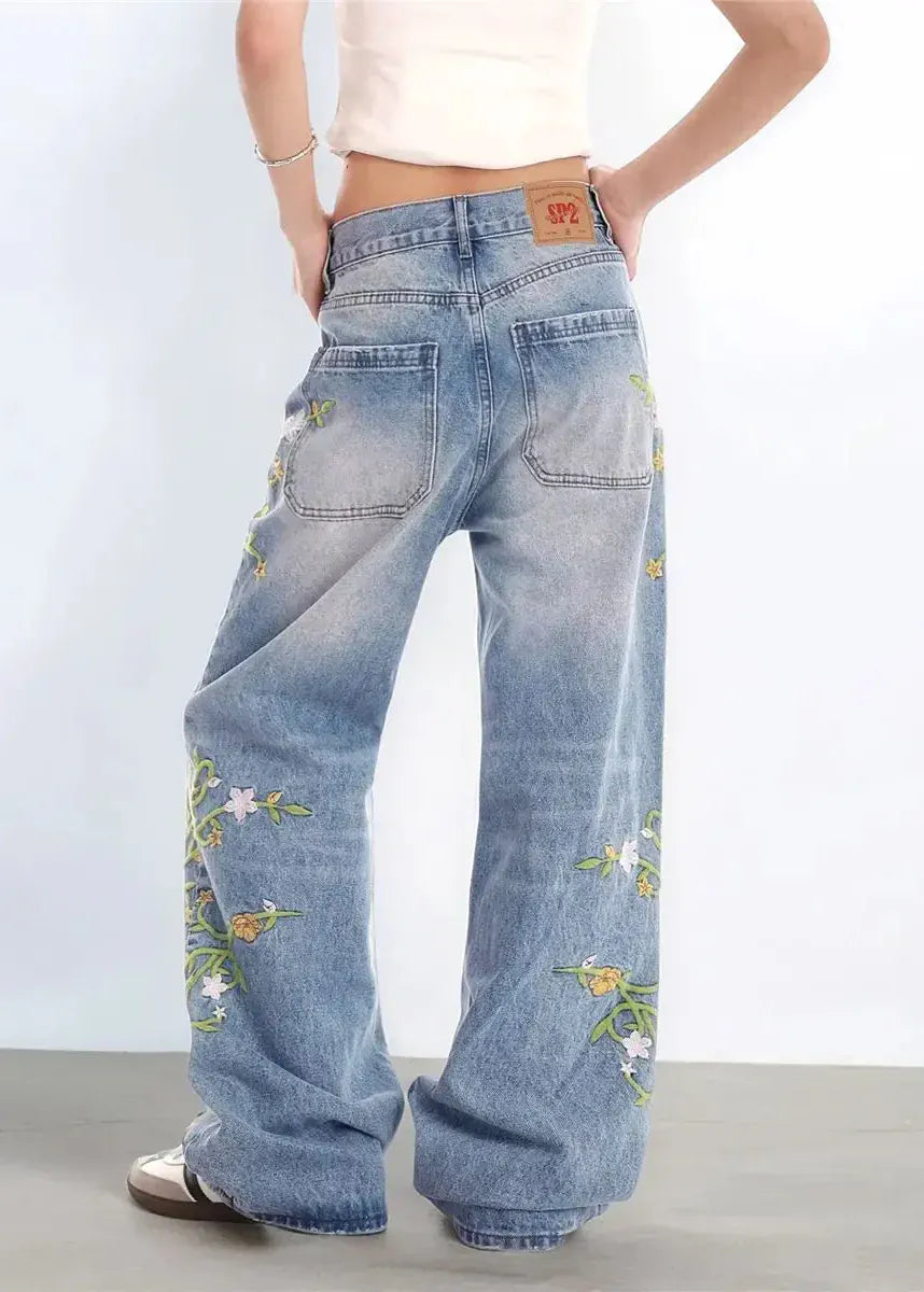Wide-leg jeans with floral embroidery on a plain background