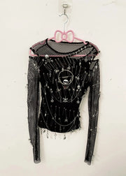 Black long-sleeve top with decorative elements on a pink hanger against a white background