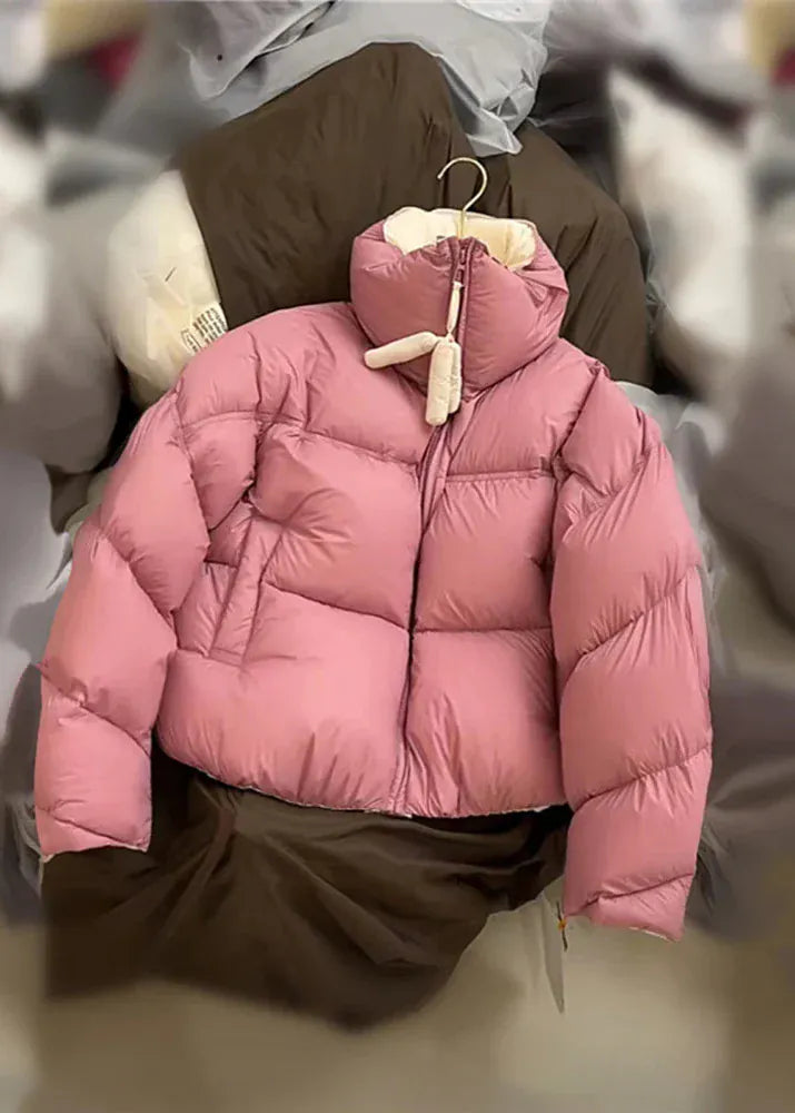 Pink puffer jacket on a hanger with a blurred background