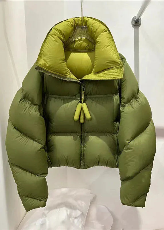 Green puffer jacket hanging against a white background