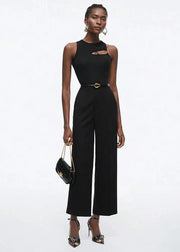 Woman wearing a black jumpsuit with cut-out design on a white background