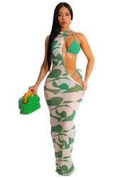 Woman wearing a green and white patterned outfit with a matching handbag on a white background.
