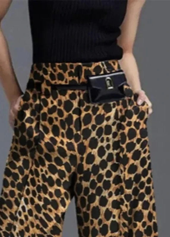 Person wearing leopard print pants with a black top on a gray background
