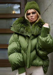 Person wearing a green puffer jacket with fur trim indoors.