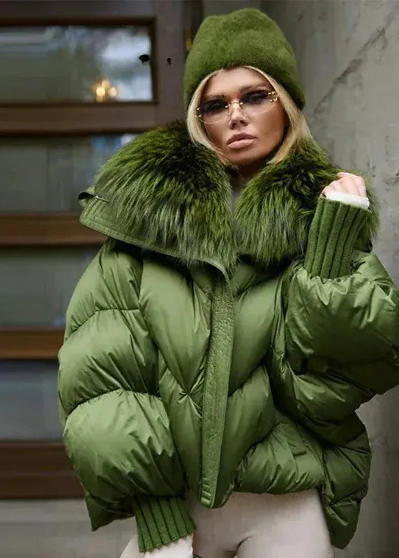 Person wearing a green puffer jacket with fur trim indoors.