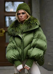 Person wearing a green puffer jacket with fur trim indoors.