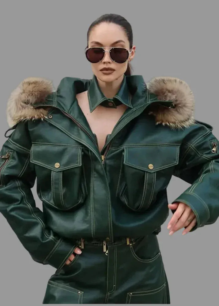 Person wearing a green leather jacket with fur trim against a plain background