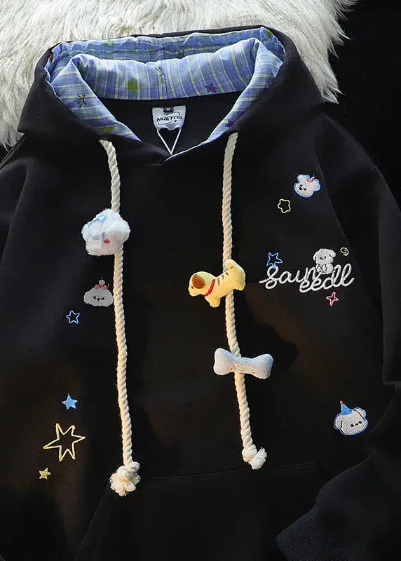 Black hoodie with cartoon character designs and text on a dark background
