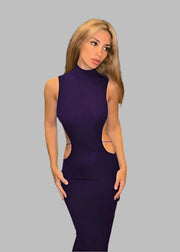 Woman in a purple dress standing in an elegant interior setting