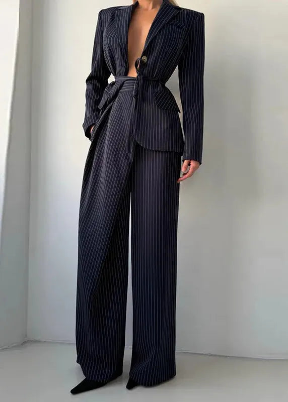 Navy pinstripe suit with wide-leg pants on a plain background
