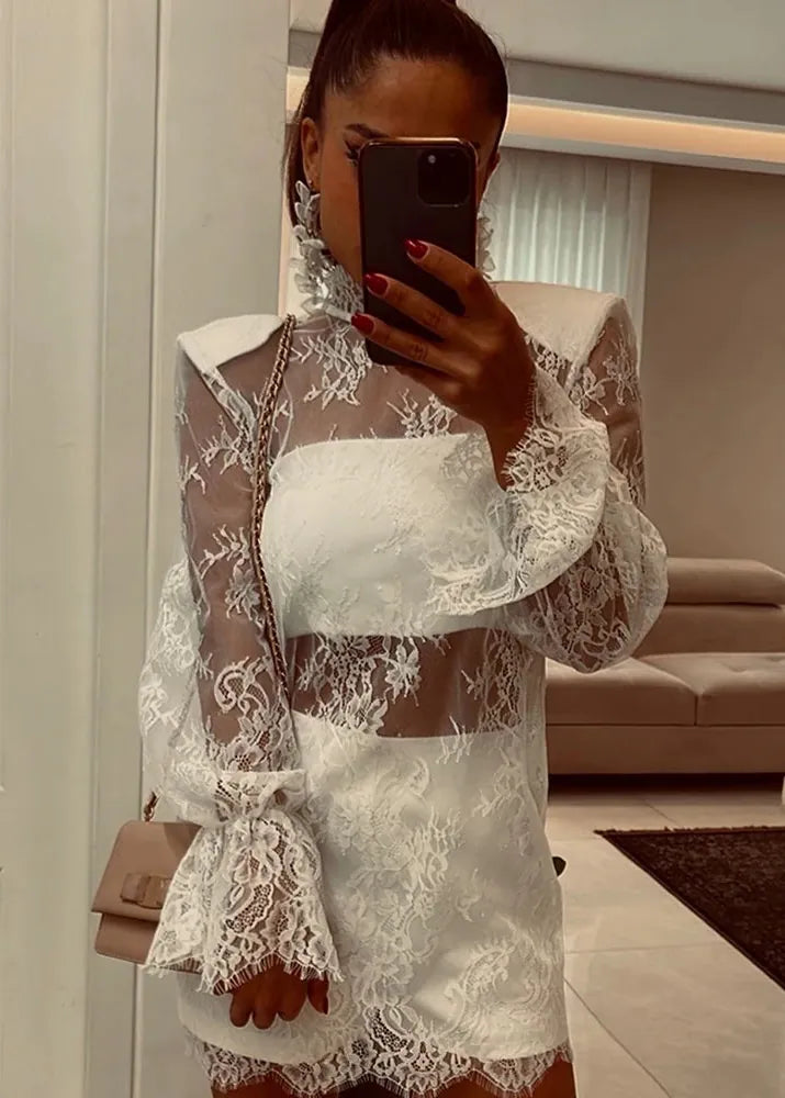 Person wearing a white lace dress taking a mirror selfie.