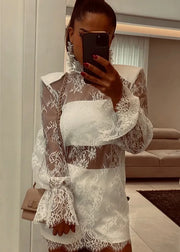 Person wearing a white lace dress taking a mirror selfie.