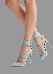 Light blue high-heeled shoes with strappy design worn by a person on a light gray background.