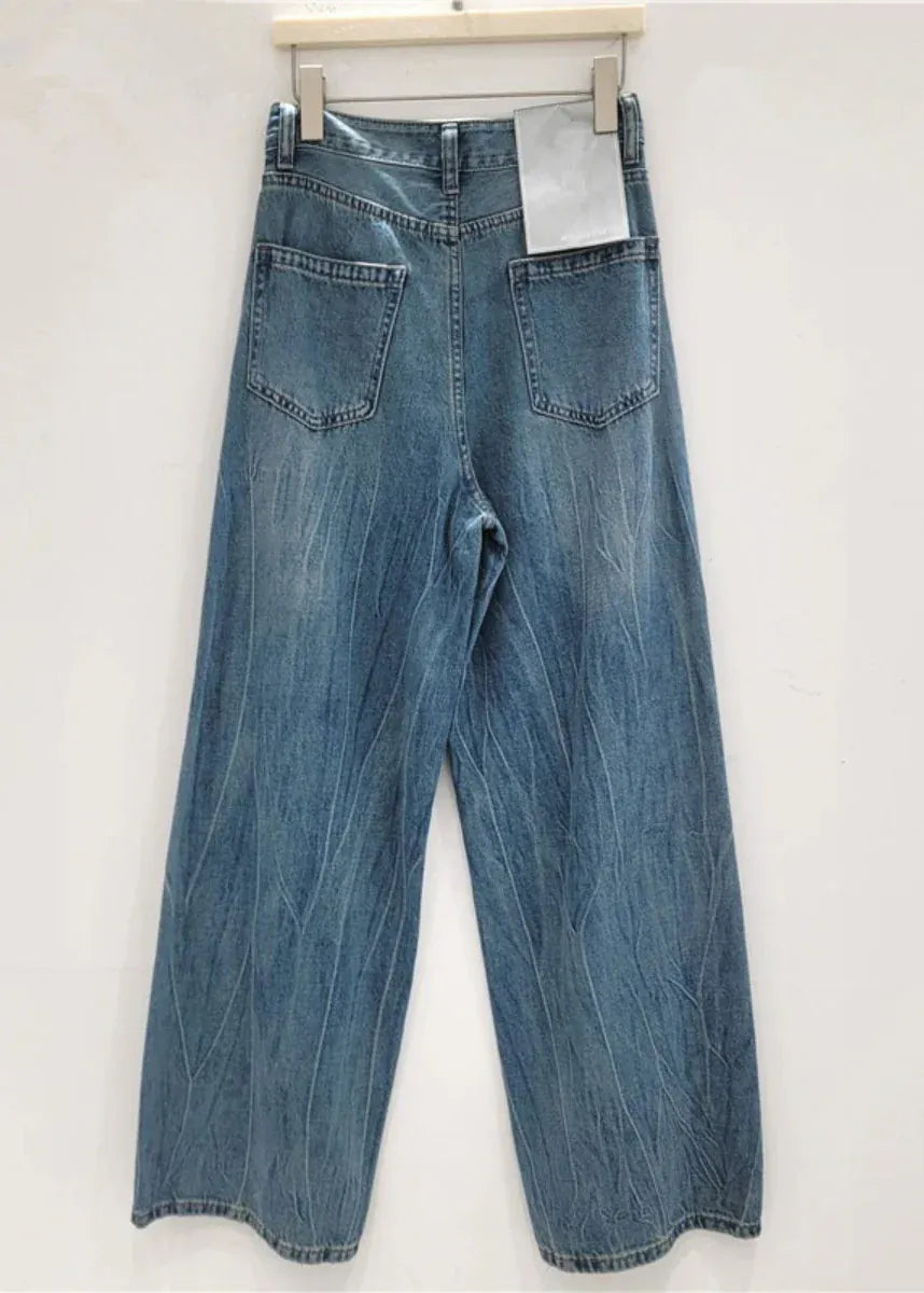 Blue jeans hanging on a white wall