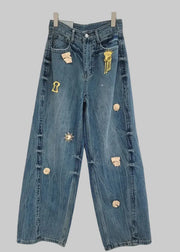 Blue jeans with decorative buttons and patches on a white background, branded 'GALCAUR'.